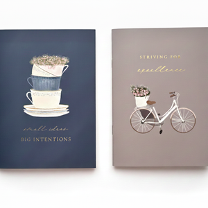 Set of two A5 softcover Islamic exercise books, featuring a warm navy blue book and a beige book, both with a floral designs and motivational islamic quotes. Ideal for Muslim stationery and journaling.