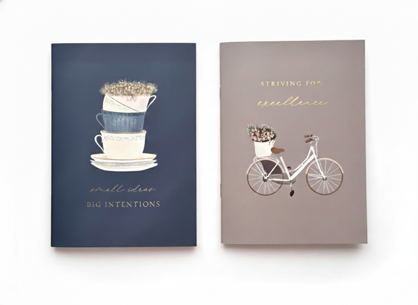 Set of two A5 softcover Islamic exercise books, featuring a warm navy blue book and a beige book, both with a floral designs and motivational islamic quotes. Ideal for Muslim stationery and journaling.