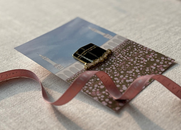 Side view of Kabah floral enamel pin with sunlight reflecting off gold and glitter details