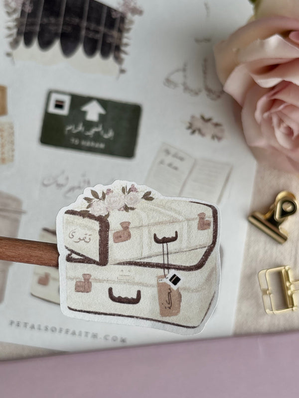 close up of vintage style makkah suitcases with floral designs, arabic calligraphy word taqwa written on suitcase 